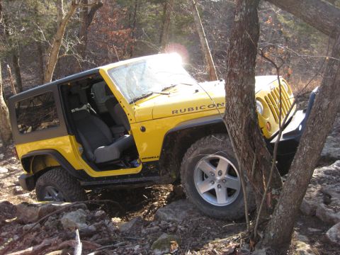 2005 Jeep Wrangler - 2005 Jeep Wrangler Rubicon shown off-roading on a rocky trail with trees.