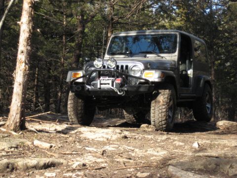 2005 Jeep Wrangler - This 2005 Jeep Wrangler navigates a , wooded terrain with its winch and off-road tires.
