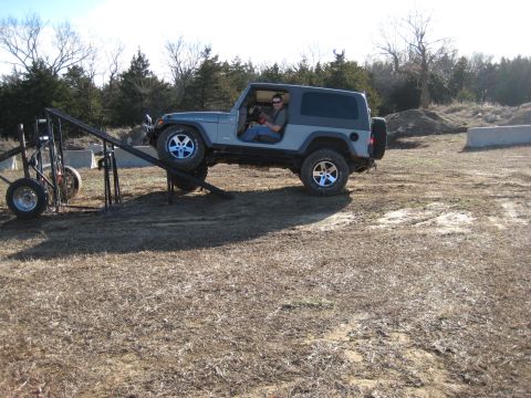 2005 Jeep Wrangler - A gray Jeep Wrangler is positioned on a metal ramp in an outdoor, dry, grassy area.