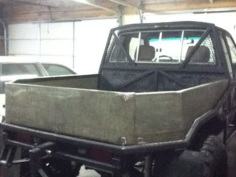 1988 Suzuki Samurai - Rear view of a truck a custom flatbed insert and a protective cage over the cab.