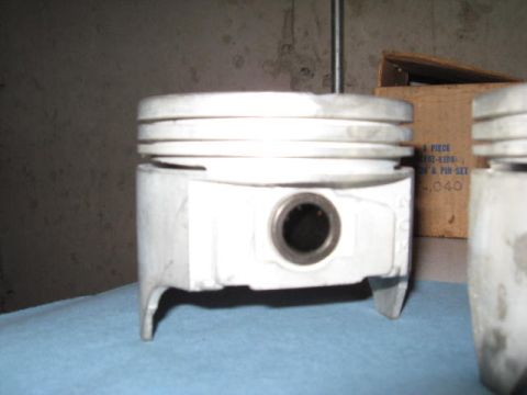 1963 Ford Galaxie - Close-up of engine pistons, one in sharp focus, with a box of parts behind it.