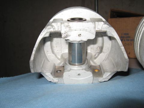 1963 Ford Galaxie - A cutaway view of a piston, revealing its internal structure including the pin bore and journal for the connecting rod.