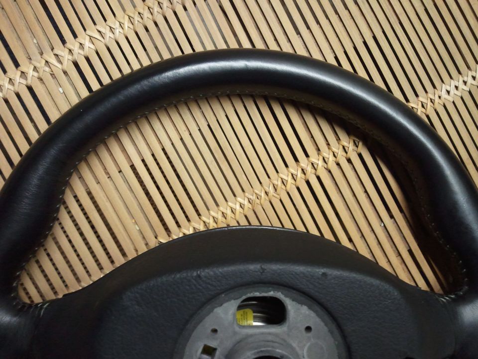 Black leather-wrapped steering wheel with visible stitching