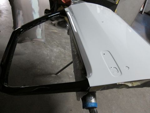 1987 Dodge 1500 - A white car door with black trim is prepped for painting.