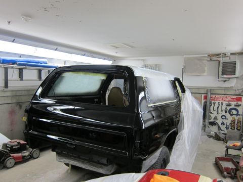 1987 Dodge 1500 - SUV in a garage, partially covered with plastic sheeting and tape, undergoing painting.