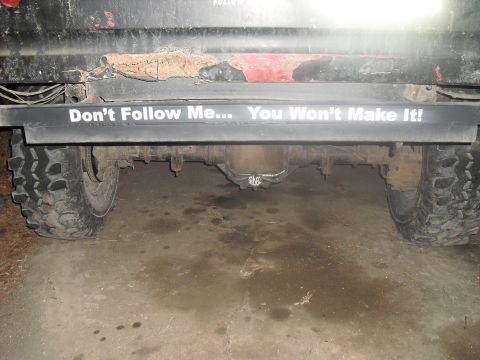 1986 Ford Bronco - Rear view of a truck's axle and tire, a humorous bumper sticker.