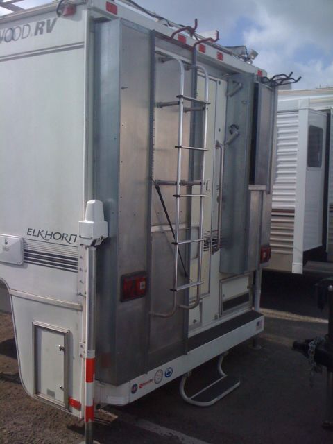 1968 Ford Mustang - Elkhorn RV truck camper shown from the rear, a ladder and exterior storage.