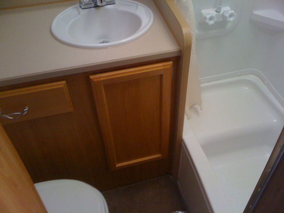 RV bathroom with sink, toilet, and shower stall