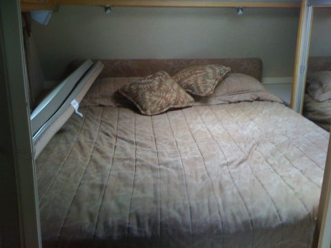 1968 Ford Mustang - Interior view of a camper bed with two pillows and a tan comforter.