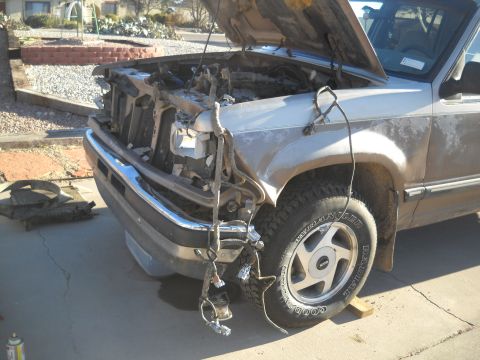 1992 Ford Explorer - The front end of a 1992 Ford Explorer is heavily damaged, with the hood open revealing the engine compartment.