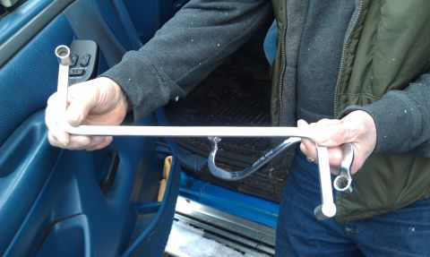 1990 Ford Bronco - A person holds tools inside a vehicle with a blue interior.