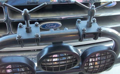 1996 Ford Bronco - Close-up of a Ford truck's front grille, showing the emblem and added lighting equipment.