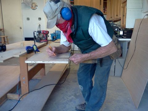 1996 Ford Bronco - Man marks wood at a workbench in a garage, with tools and materials visible.