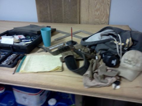 1996 Ford Bronco - A collection of tools and personal items are scattered across a wooden workbench.