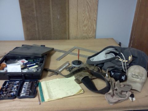 1996 Ford Bronco - A collection of tools and personal items are laid out on a wooden workbench.