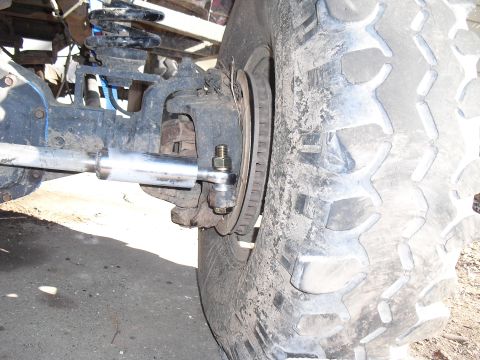 1986 Ford Bronco - A detailed view of the suspension and tire assembly of an off-road vehicle.