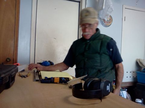 1996 Ford Bronco - A man stands behind a workbench with various tools and a pair of headphones in front of him.
