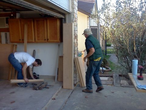 1996 Ford Bronco - Men are working with lumber and tools in a garage setting.