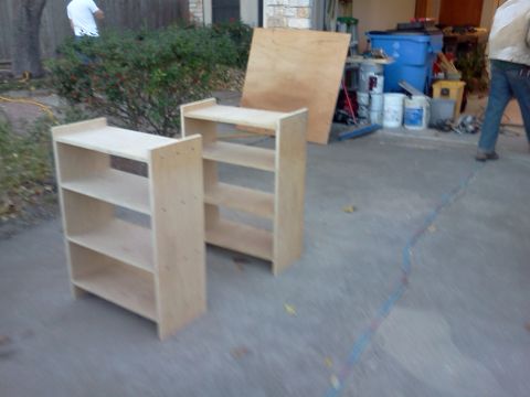 1996 Ford Bronco - Two unfinished wooden shelves are placed on a concrete driveway, with building materials in the background.