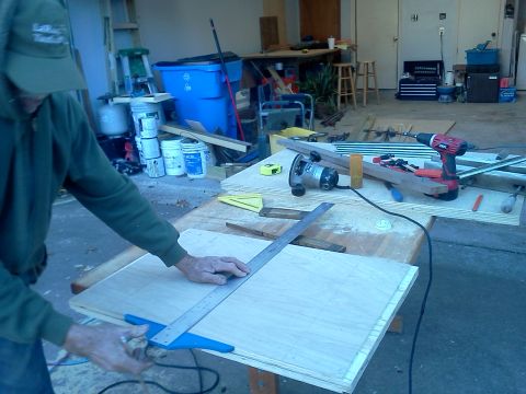 1996 Ford Bronco - A person uses a measuring tool on plywood at a workbench with various tools and materials.