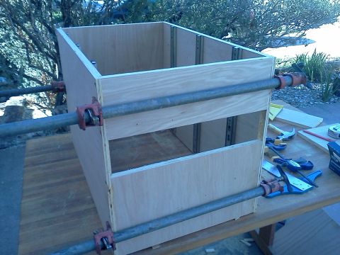 1996 Ford Bronco - A wooden cabinet is being assembled using pipe clamps, showing the internal drawer slides and unfinished plywood construction.