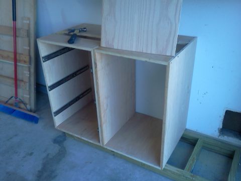 1996 Ford Bronco - A partially constructed wooden cabinet with visible drawer slides sits on a concrete floor.