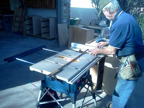1996 Ford Bronco - Man operating a table saw with unfinished cabinets visible in the background.