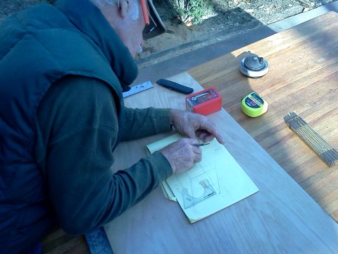 1996 Ford Bronco - A man is focused on drawing a technical diagram on a piece of paper, surrounded by various tools.