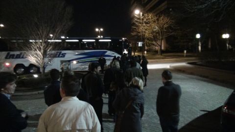1993 Ford Taurus - A group of people board a white bus labeled 'Indi-Trails' at night.