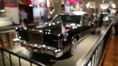 1993 Ford Taurus - A black limousine with flags is displayed indoors, likely as an exhibit.