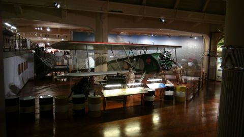 1993 Ford Taurus - A biplane is displayed in a museum setting with various exhibits around it.