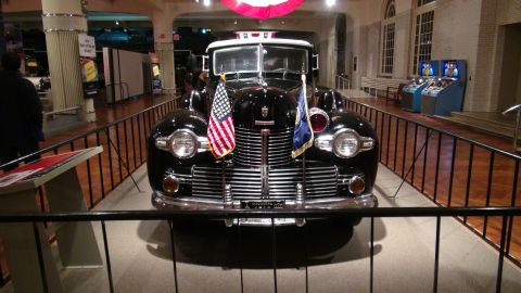 1993 Ford Taurus - This vintage limousine, likely from the 1940s, is displayed indoors with flags.