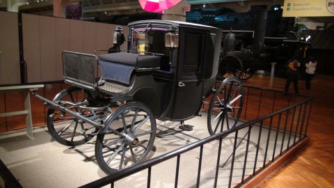 1993 Ford Taurus - A horse-drawn carriage is displayed indoors, with a steam engine visible in the background.