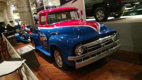 1993 Ford Taurus - A vintage blue and red Ford pickup truck is displayed indoors, possibly at a museum or car show.
