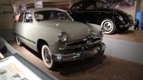 1993 Ford Taurus - Two classic cars, a 1950 Ford and a Volkswagen Beetle, are exhibited indoors.