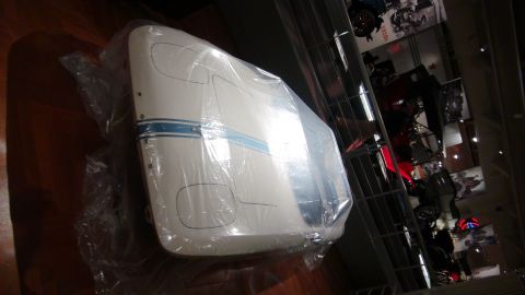 1993 Ford Taurus - A white car fender with a blue stripe, wrapped in plastic, is displayed.