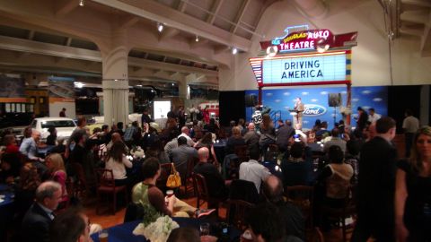 1993 Ford Taurus - A white sedan is visible in the background of a crowded event hall.