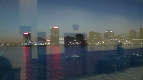 1993 Ford Taurus - A city skyline is visible across a body of water at dusk, with building lights reflecting on the surface.