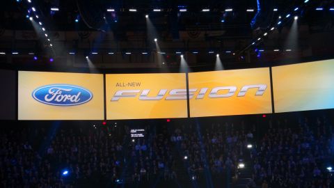 1993 Ford Taurus - A large screen displays the Ford logo and the text 'ALL-NEW FUSION' during an event.