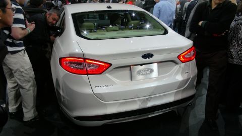 1993 Ford Taurus - White Ford Fusion sedan seen from the rear at an auto show.