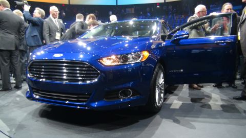 1993 Ford Taurus - A blue Ford sedan is displayed with its driver's door open, revealing a 'HYBRID' badge on the lower door panel.