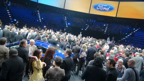 1993 Ford Taurus - A blue car is displayed at a crowded Ford auto show event.