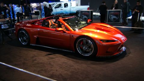 1993 Ford Taurus - Orange convertible sports car on display at an auto show.