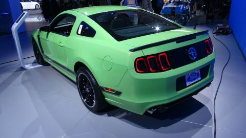 1993 Ford Taurus - A bright green Ford Mustang is displayed indoors, likely at an auto show.