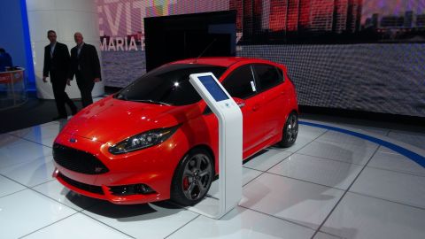 1993 Ford Taurus - A red hatchback with an ST badge is showcased at an auto show.