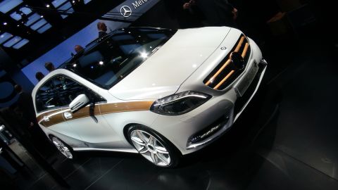 1993 Ford Taurus - White Mercedes-Benz with a distinctive gold stripe accent is displayed at an auto show.