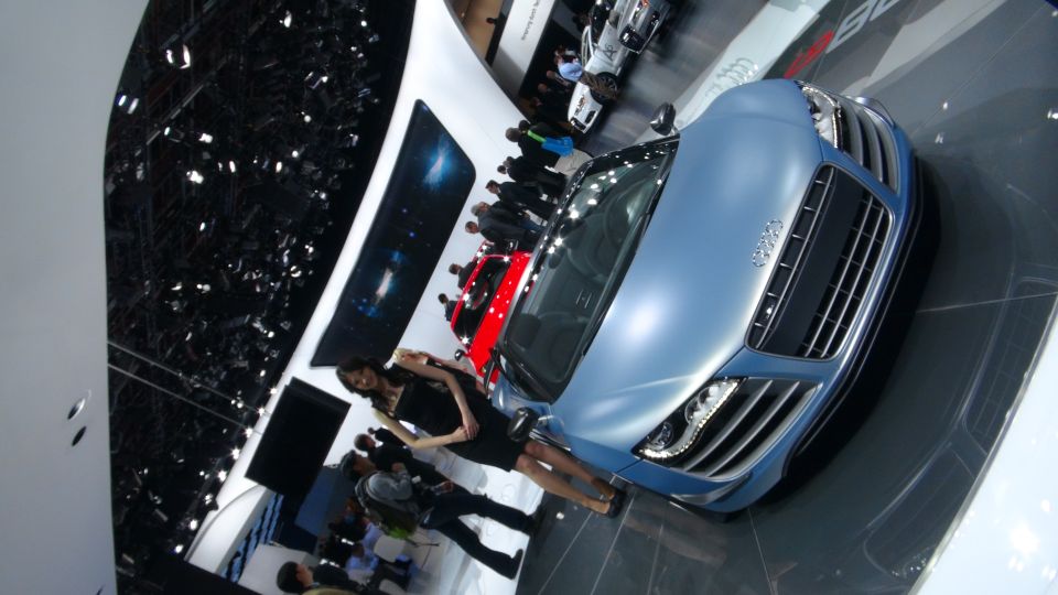 Blue sports car with a prominent grille and headlights, angled view