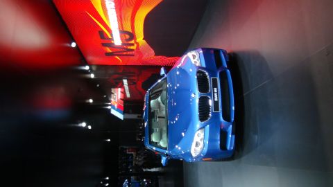 1993 Ford Taurus - Blue BMW M5 with racing stripes displayed at an auto show with "M5" signage in the background.