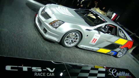1993 Ford Taurus - A silver Cadillac CTS-V race car is displayed with "CTS-V RACE CAR" visible on a plaque below.