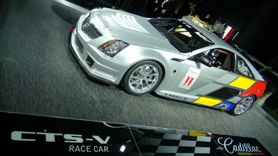 Silver Cadillac CTS-V race car with colorful graphics and racing number 11
